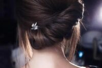 43 a modern low updo with a twisted low chignon and a voluminous top plus some locks down is a stylish idea
