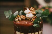 44 a chocolate naked wedding cake with caramel drip, nuts, meringues, nuts and eucalyptus is a beautiful option
