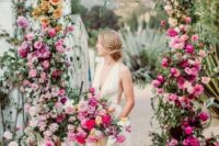 45 a bright ombre floral wedding arch with light and pale pink, orange and peachy, blush and hot pink blooms and greenery is wow