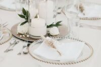 46 a refined wedding tablescape with metallic trays with candles and blooms, sheer chargers and neutral linens with dried blooms
