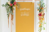 46 a stylish mustard wedding sign on a copper arch, with bright blooms and greenery is a stylish idea for a modern wedding