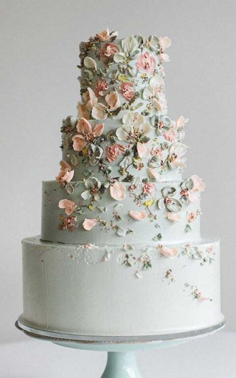 a pastel green wedding cake decorated with gorgeous naturally-looking sugar blooms and leaves is amazing