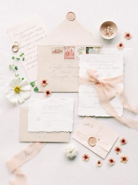 a romantic summer wedding invitation suite with blush envelopes and ribbon, raw edge invites and beautiful calligraphy