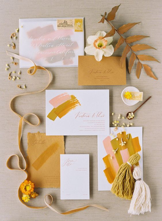 a stylish mustard, pink and white wedding invitation suite with brushstrokes and tassels is a cool and catchy idea for a modern wedding