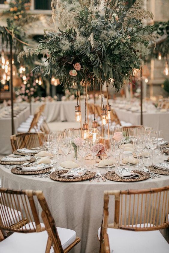 a stylish neutral summer wedding tablescape with a lush textural green centerpiece with bulbs, woven placemats and neutral porcelain