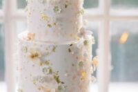 49 a white wedding cake decorated with tiny pastel sugar blooms, gold leaf and pearls looks very refined