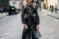 50 a gorgeous navy pantsuit with tan floral prints, with illusion sleeves, cropped pants, tan shoes and a light blue bag