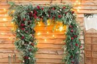 52 a gorgeous Christmas wedding arch shaped as a frame, covered with evergreens, greenery, red roses and with lots of candle lanterns around