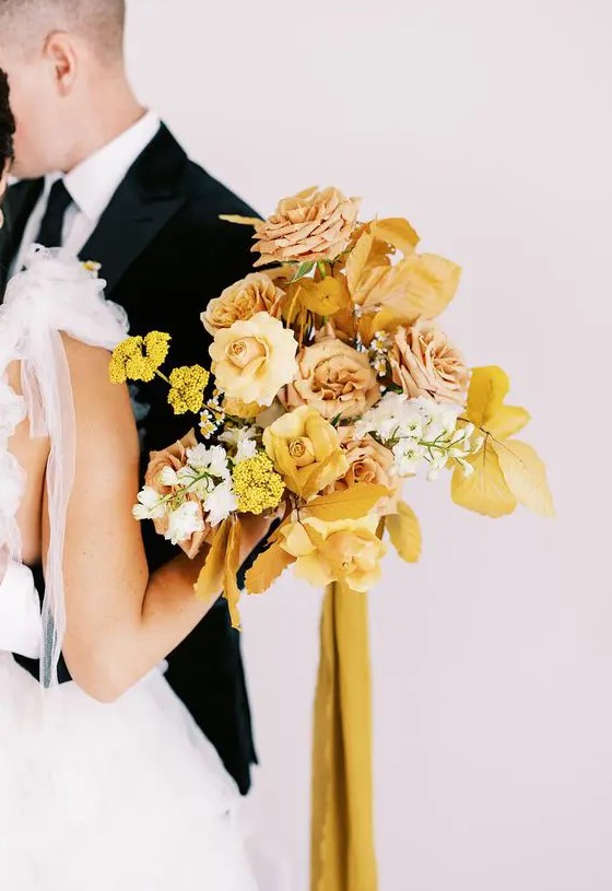 a yellow wedding bouquet with roses, peony roses, mimosas, fall leaves and mustard ribbons is a cool idea for the fall