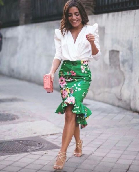 a white blouse with accented shoulders, a green flare floral skirt, nude strappy heels and a pink clutch