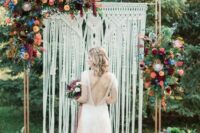 55 a macrame wedding backdrop with bright orange, burgundy, peachy pink and blue flowers plus greenery