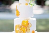 56 a creative white wedding cake with dried citrus slices and some blooms is a cool and bold wedding dessert