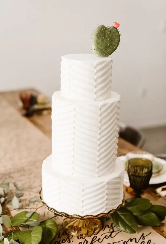 a white chevron pattern wedding cake with a sugar cactus and a bloom for a desert wedding