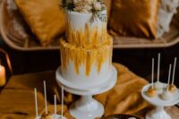 57 a delicious boho wedding desserts bar with a wedding cake with marigold textural patterns and gold and white sweets