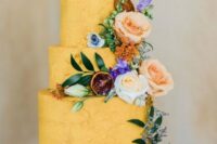 58 a marigold textural buttercream wedding cake decorated with fresh blooms, greenery, dried citrus and a pear