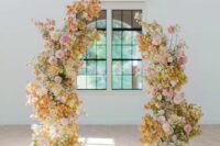 60 a vivacious wedding arch with light pink and blush, white and yellow blooms and some leaves is a cool idea for a bold wedding