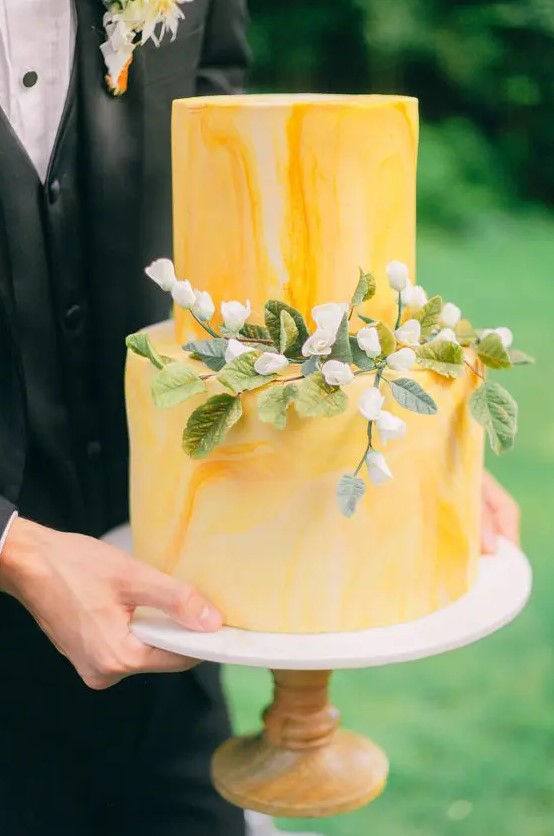 a yellow marble wedding cake with blooms and greenery is a bright and elegant idea for spring or summer
