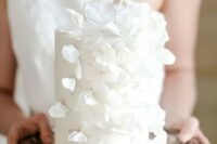 60 an ethereal white wedding cake decorated with beads and pearls plus white sugar leaves and petals is amazing
