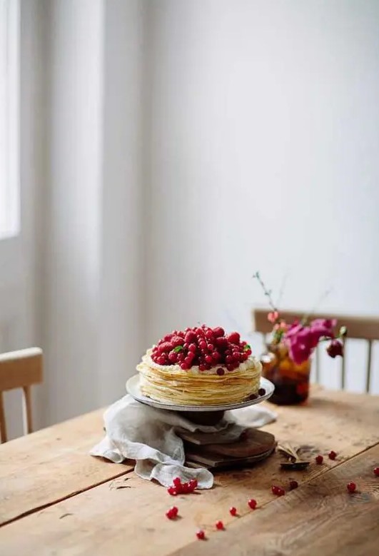 a crepe wedding cake topped with fresh red berries is a lovely idea for a summer wedding or for a fall one