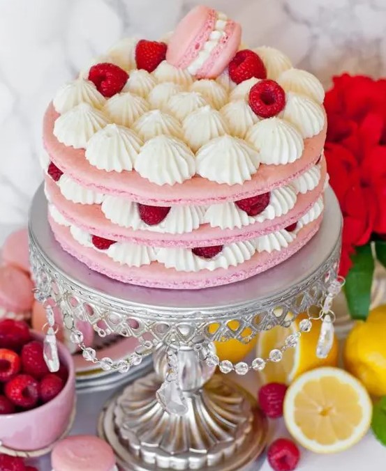 a gorgeous and delicious pink macaron cake with vanilla cream, raspberries and a pink macaron on top is amazing