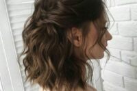 a beautiful dark brown medium length wavy half up hairstyle with a wavy top, locks framing the face and waves down