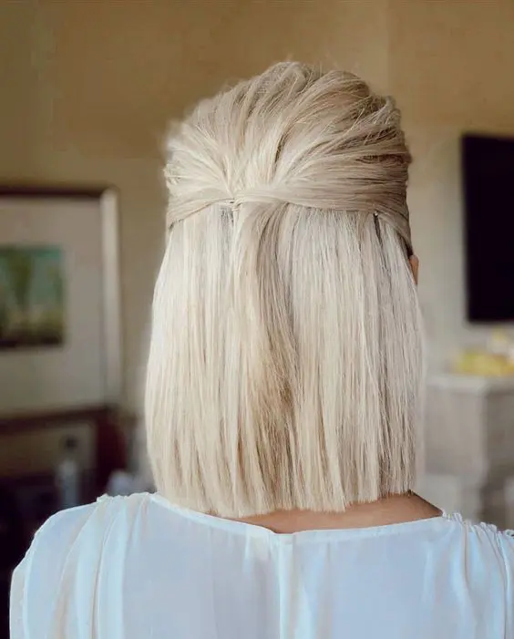 a blonde medium length half updo with a textured top and straight hair down is great for a minimalist bride