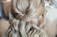 a chic blonde half updo with a twisted element, a bump and waves down is a catchy idea for many styles