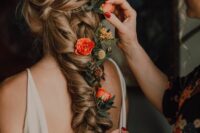 a fabulous loose and messy long braid with bold flowers and greenery tucked in is a gorgeous idea for a summer bride