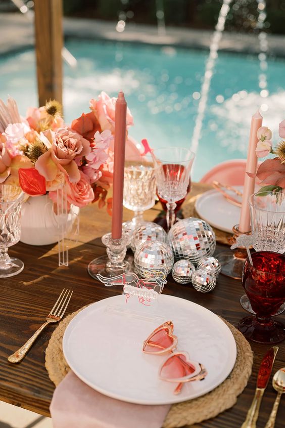 a pretty eclectic wedding centerpiece of silver disco balls, rust candles, pastel blooms and bright ones, is ideal for a bold and fun wedding