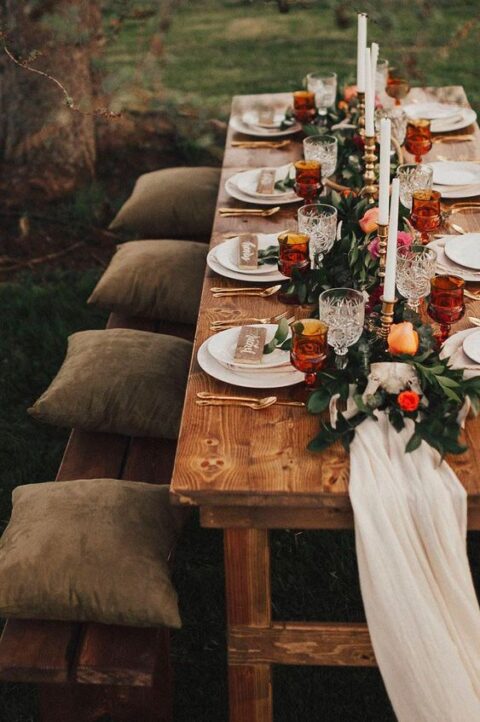 a refined bright micro wedding tablescape with a greenery and bold flower runner, candles, amber glasses and wooden cards