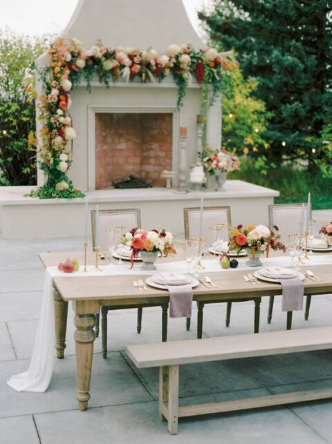 a refined micro wedding tablescape with a white runner, lilac napkins, white plates, lush fall-colroed florals and grey candles