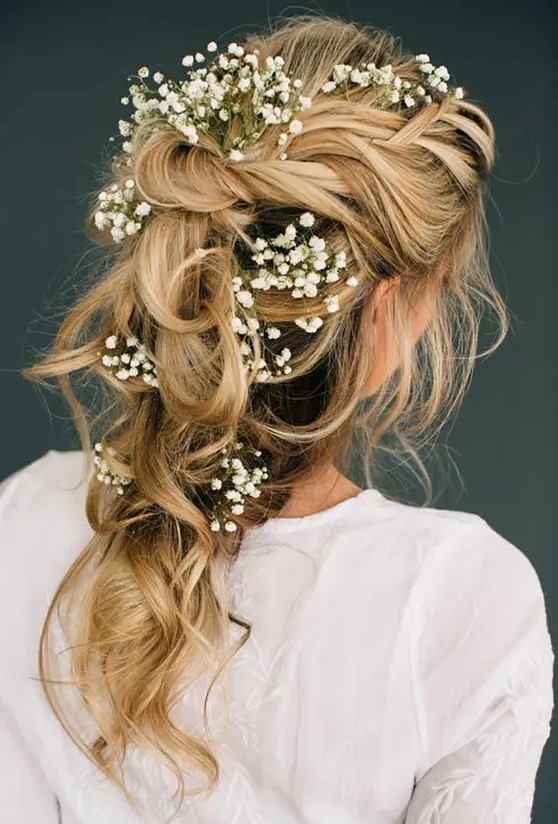 a romantic tousled bridal braid adorned with baby's breath looks ethereal and will be perfect for a boho bride
