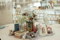 an eclectic wedding centerpiece of lace, book stacks, blooms, paper flowers, vintage photo frames is amazing