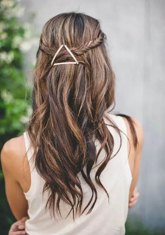 A fishtail braided half updo with waves and an eye catchy geometric hairpiece that adds a boho feel