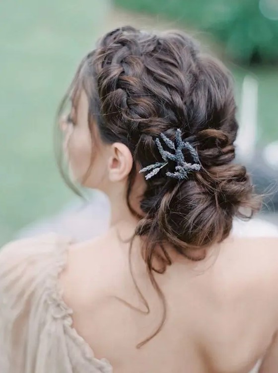 a beautiful braided updo with messy touches, some locks down and some lavender tucked in for a romantic bride