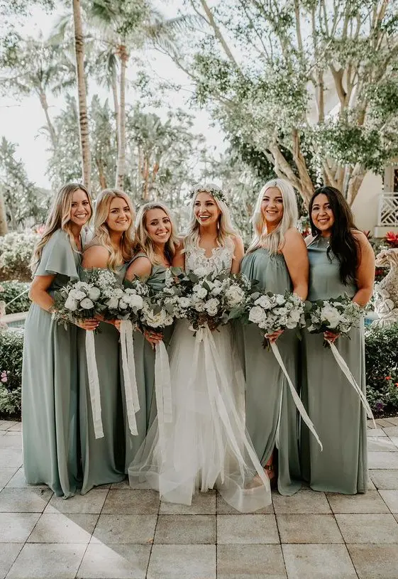 mismatching sage green bridesmaid dresses and a white lace wedding dress with a layered skirt