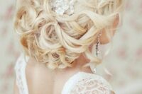 05 a stunning low wedding updo on long hair with a shiny rhinestone hairpiece and a slight volume on top