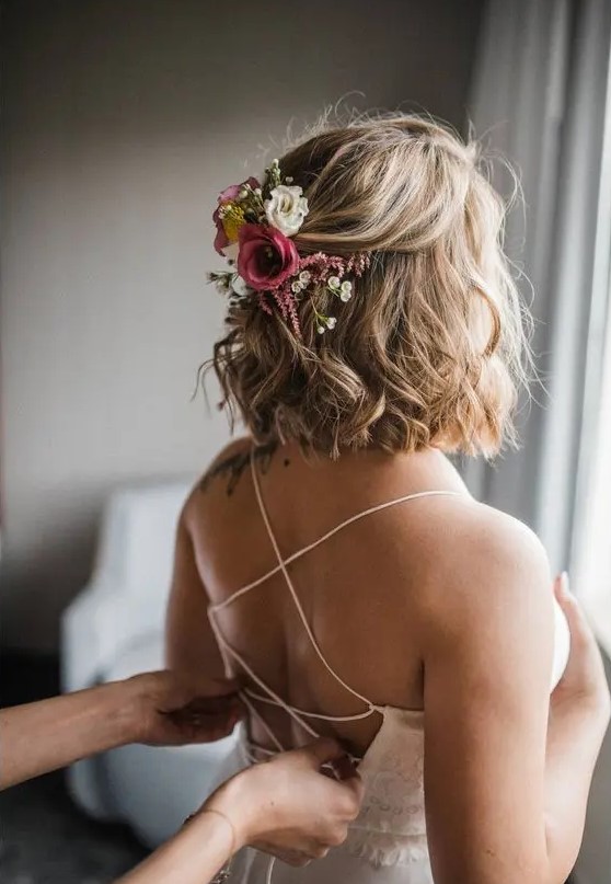 a romantic half updo with waves and a texture and some fresh blooms tucked in is a lovely idea for a romantic bride