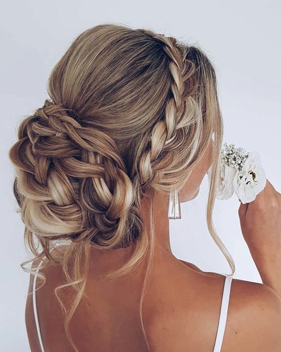 a braided wedding updo with a braided halo, a bump on top and a braided bun plus some locks down is chic and cool
