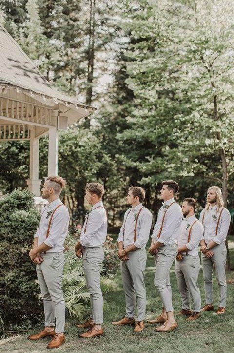 groomsmen wearing white shirts, sage green pants, brown shoes, brown suspenders and boutonnieres