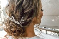 10 a messy wavy low bun with some locks down and a bead and pearl hair piece is a chic and cool idea for a wedding