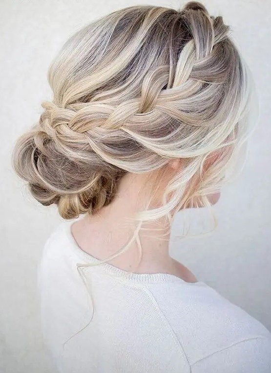 a chic braided halo with a low bun and waves down is great for a rustic or boho bride or bridesmaid