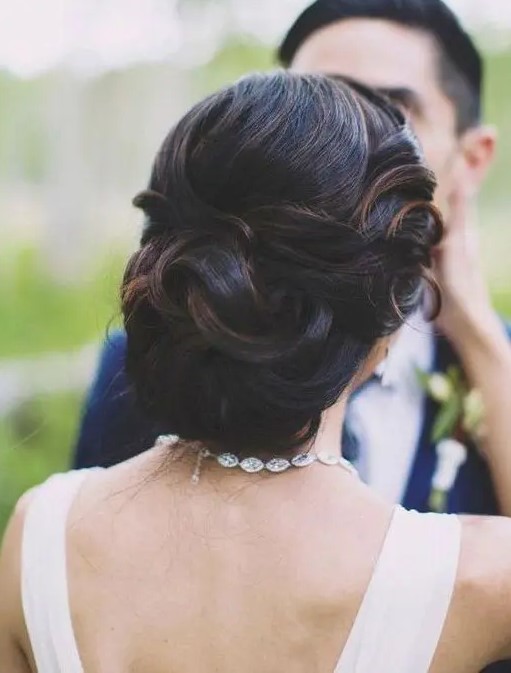 elegant curled wedding updo with a volume and with some highlights to show off the locks and the volume