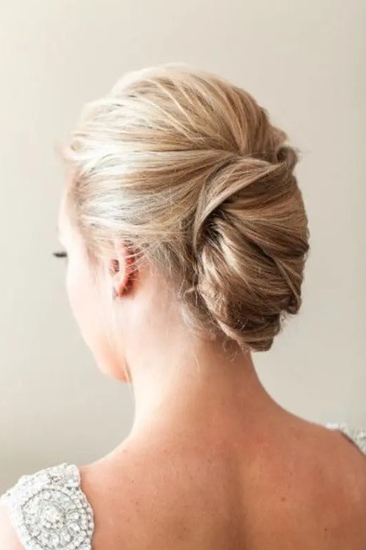 a tight French twist updo with a volume on top on balayage hair for a chic and stylish look