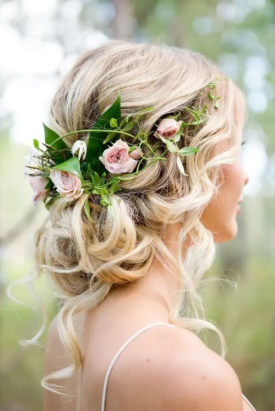 a beautiful updo with fresh flowers and lots of locks hanging down is a romantic and pretty solution for a garden wedding