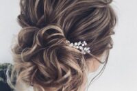 14 a beautiful wavy wedding updo with a wavy top and a low bun, a rhinestone hairpiece is a cool idea for long and medium hair