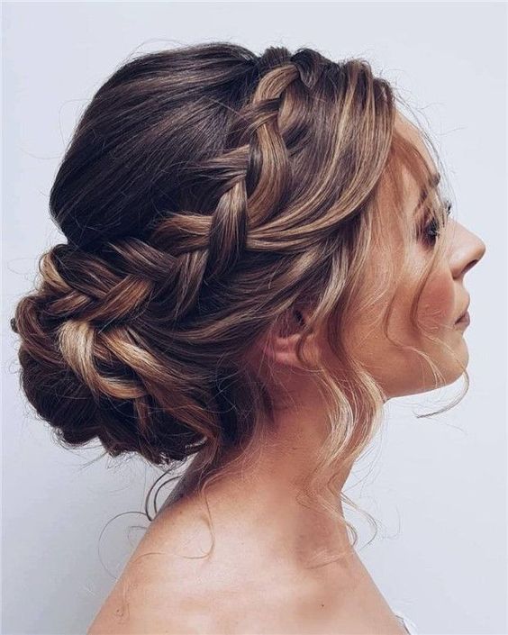 a cool low updo with a bun, a braided halo and a bump on top plus some locks down is an amazing idea