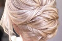 15 a beautiful blonde twisted low chignon with a bump on top and some locks down is a chic and formal idea