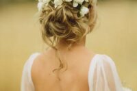 17 a messy and textured wavy low updo with some locks down and fresh blooms tucked in is a very chic and cool idea