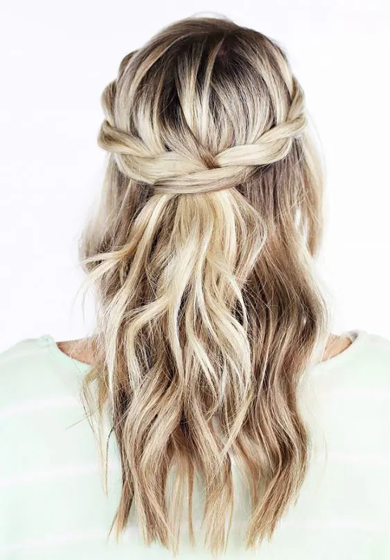 a simple boho or rustic wedding half updo with a braided halo, waves down is a cool idea for relaxed bridal styles